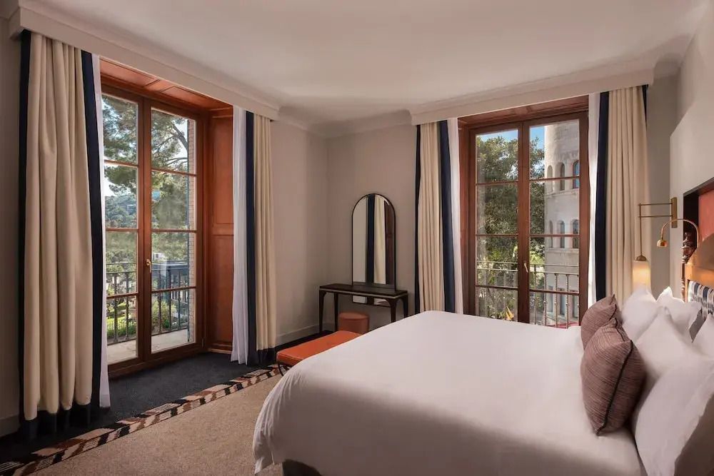 Helles Schlafzimmer in einer klassischen Suite mit Blick auf grüne Landschaft