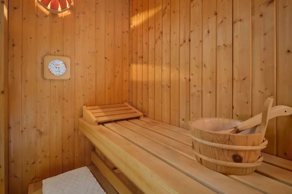 Gemütliche Holzsauna mit warmem Licht in der Suite.