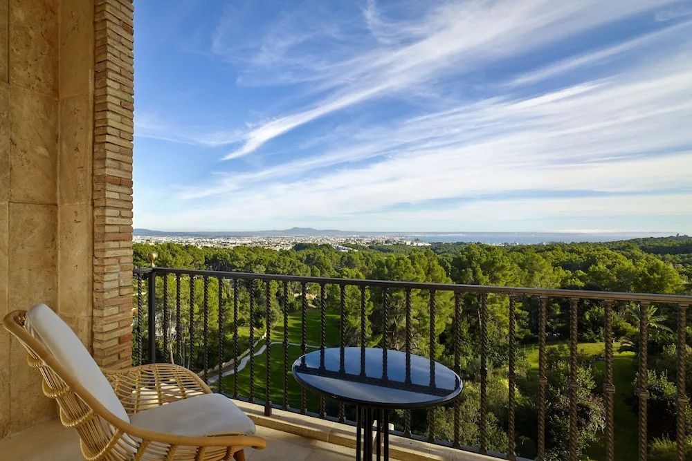 Balkon mit Blick auf Wald und Meer unter klarem Himmel, idyllische Aussicht.