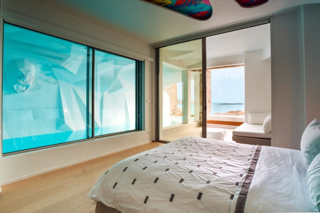 Schlafzimmer mit stilvollen Fenstern und direktem Zugang zur Terrasse mit atemberaubendem Meerblick