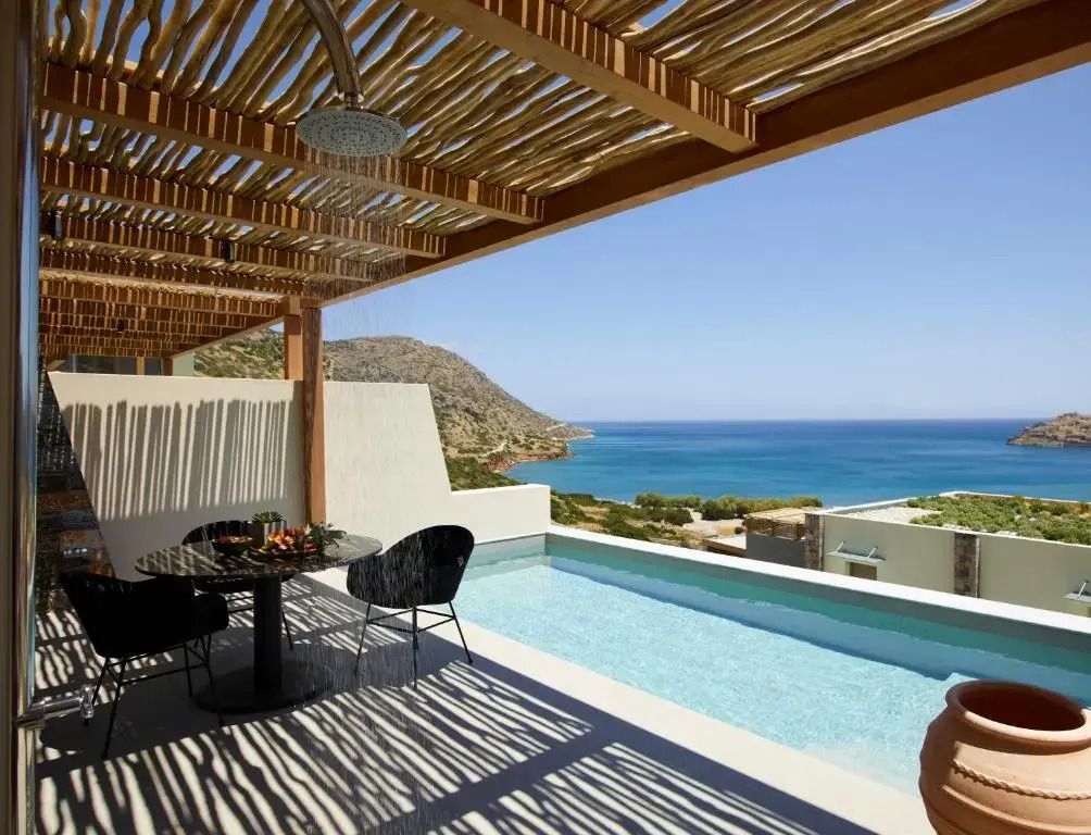 Terrasse mit privatem Pool und Meerblick unter einer Holzpergola