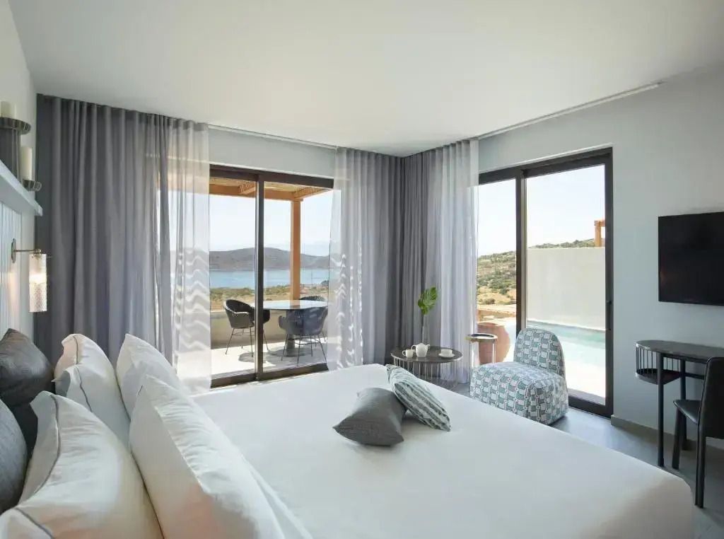Hotelzimmer mit modernem Design und Zugang zu einer privaten Terrasse mit Meerblick