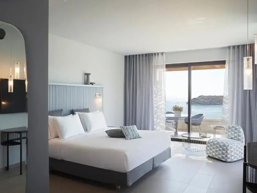 Geräumiges Zimmer mit Doppelbett und Terrasse mit Meerblick.