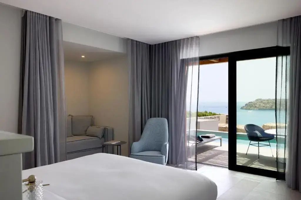 Zimmer mit Blick auf den Balkon und das Meer im Hintergrund.