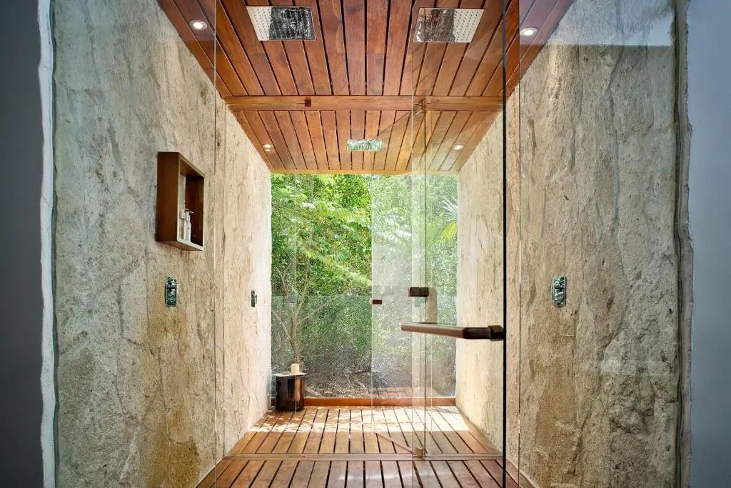 Dusche mit Glaswand und Holzverkleidung im luxuriösen, naturverbundenen Design