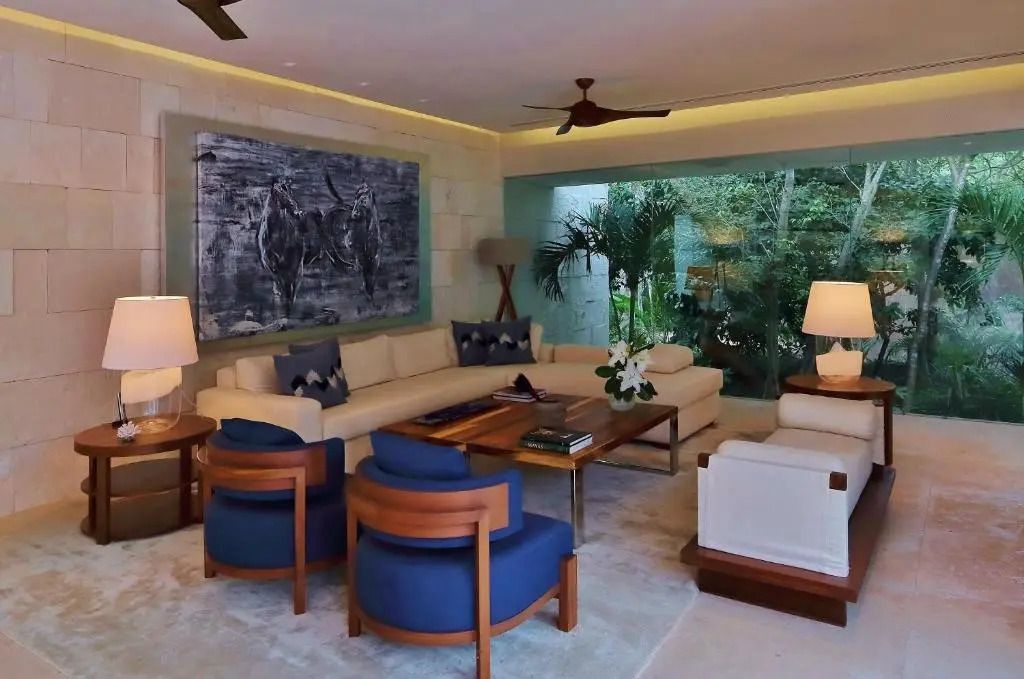 Gemütliches Wohnzimmer mit Sofas, Sesseln und großer Fensterfront