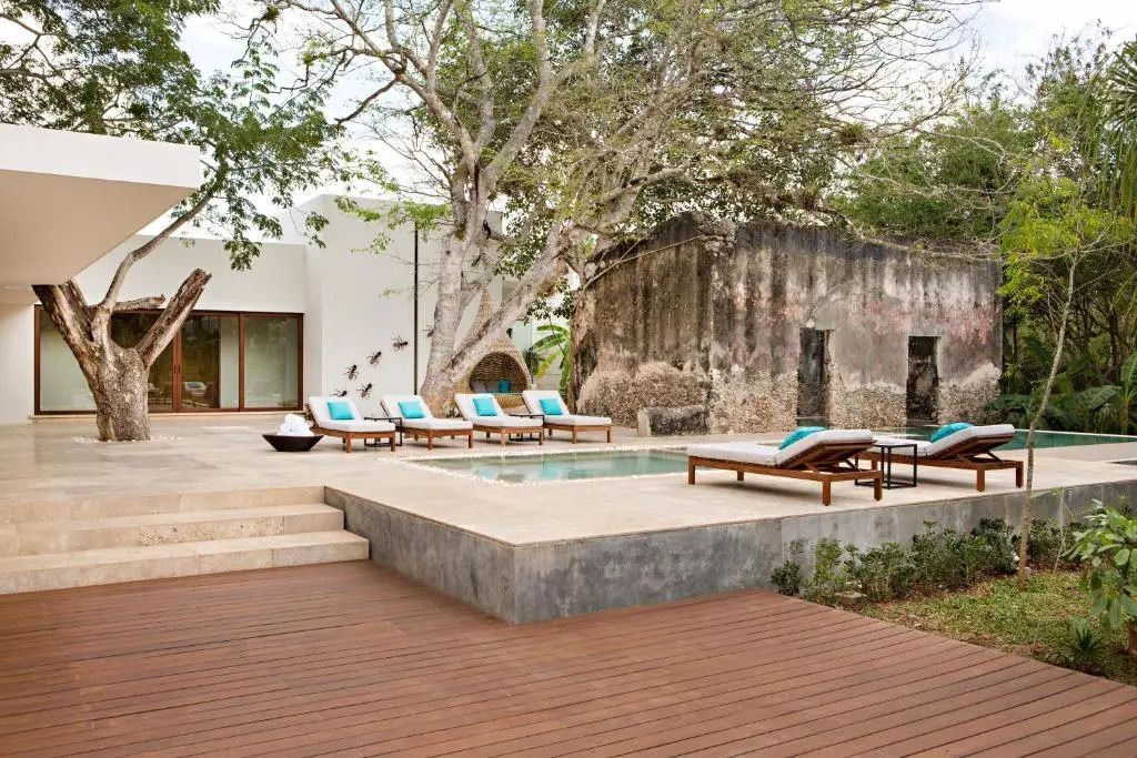 Privater Pool mit Liegestühlen und umliegender Natur im tropischen Stil