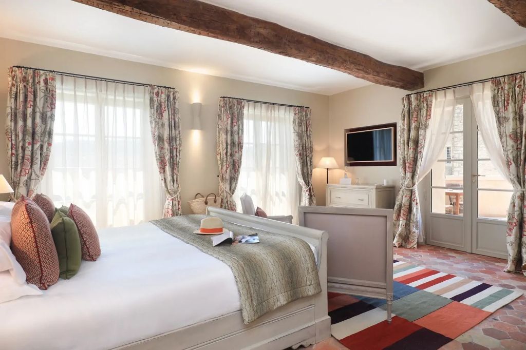 Großzügige Junior-Suite mit Holzbalken und Blick auf einen Balkon