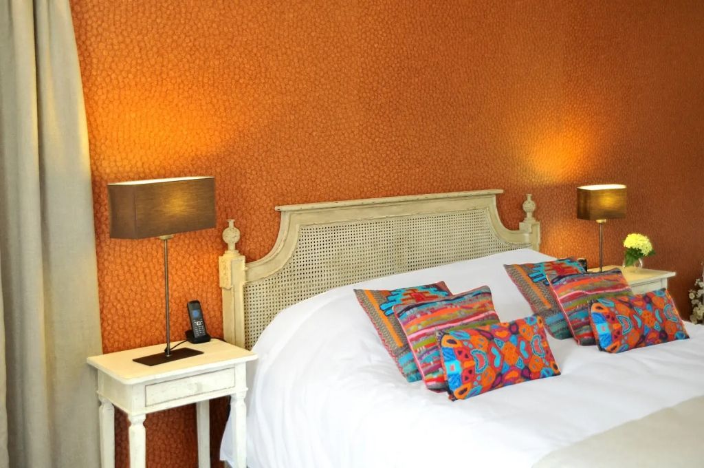 Doppelbett mit farbenfrohen Kissen in einem stilvollen Schlafzimmer