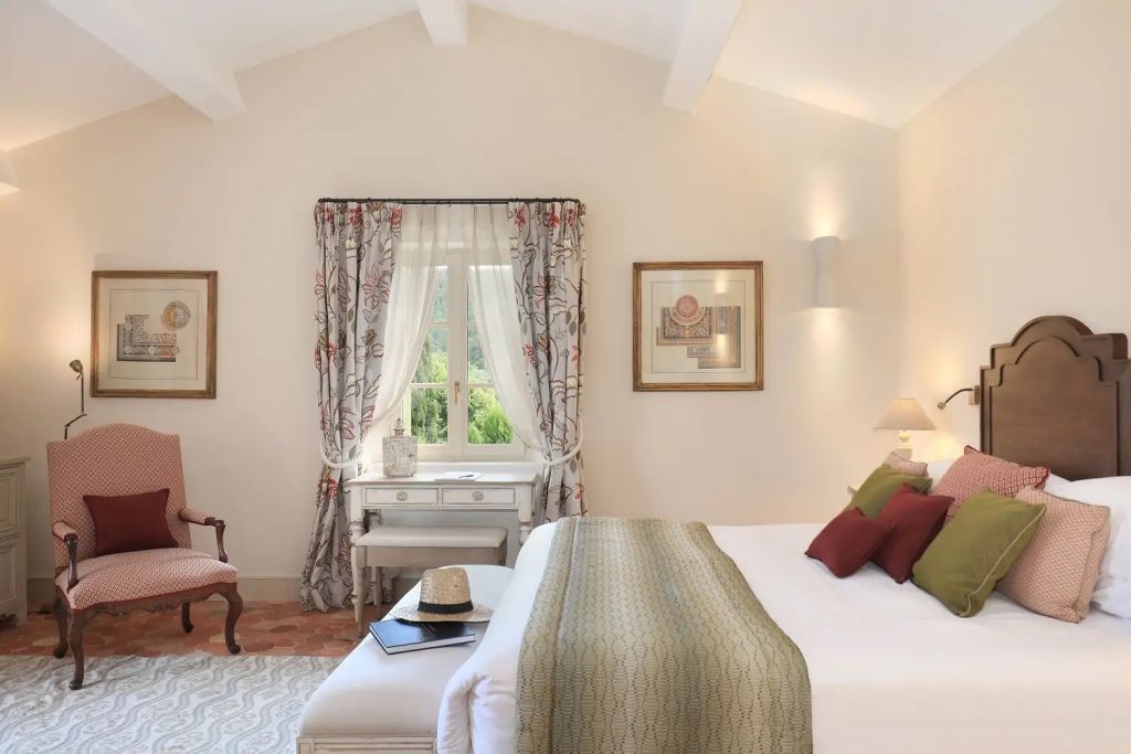 Helles Schlafzimmer in Suite mit Doppelbett und dekorativen Vorhängen