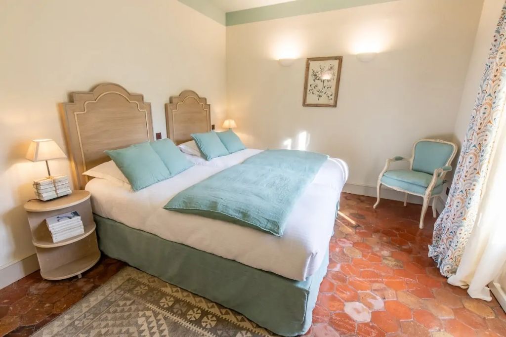 Gemütliches Hotelzimmer mit großen Doppelbett und weichen Kissen in sanften Farben.