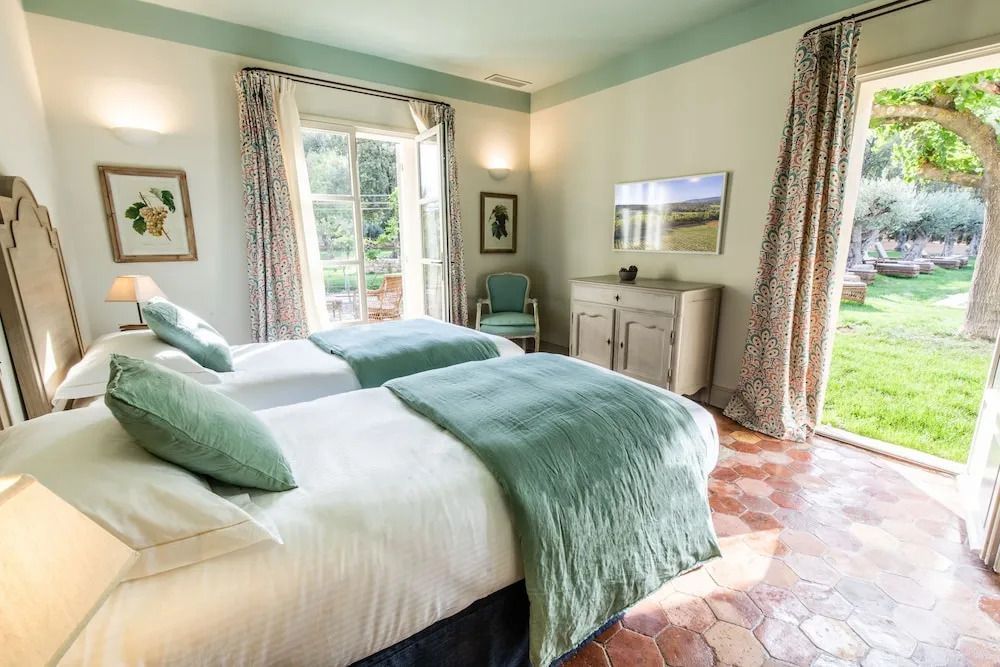Elegantes Schlafzimmer mit zwei Einzelbetten und Blick in den Garten.