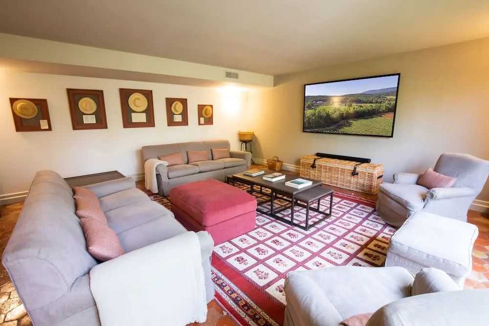 Großzügiger Wohnbereich mit komfortablem Sofa und großer Leinwand.