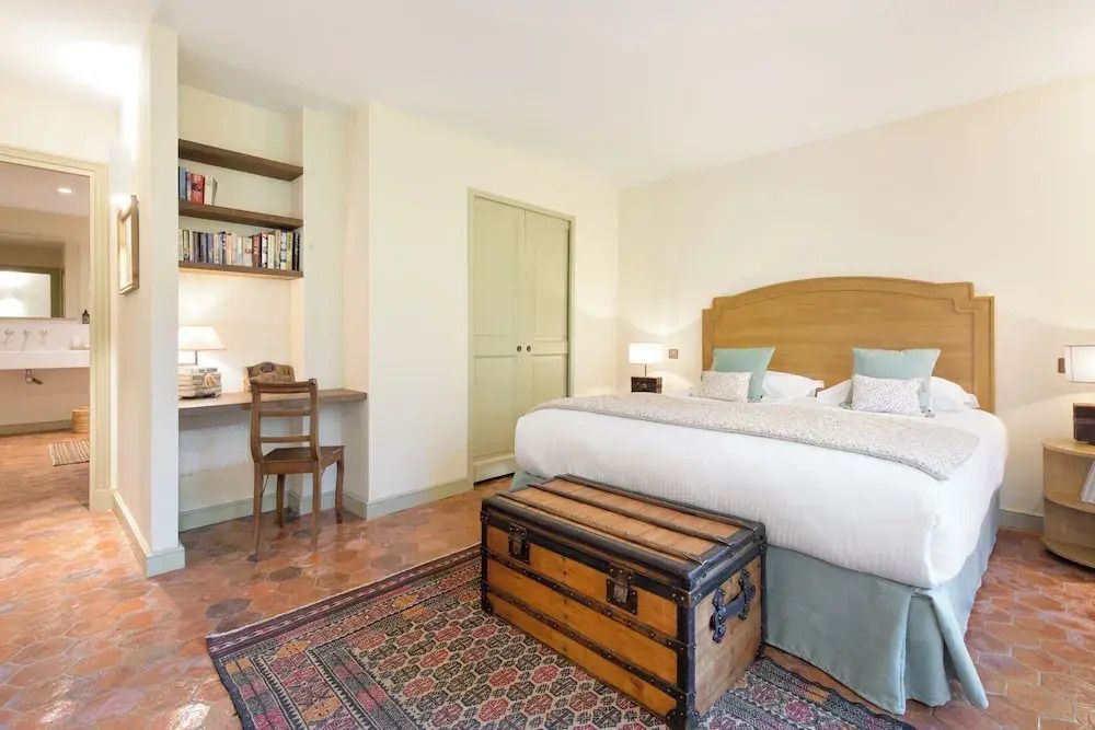 Gemütliches Schlafzimmer mit Doppelbett und hölzerner Truhe als Couchtisch.