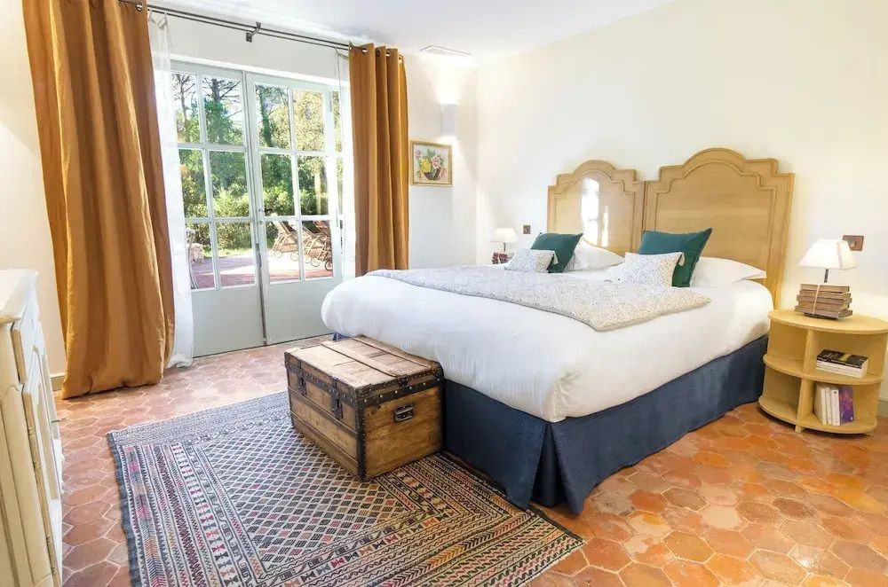 Helles Schlafzimmer mit Terrakottaboden und französischen Türen zum Garten.