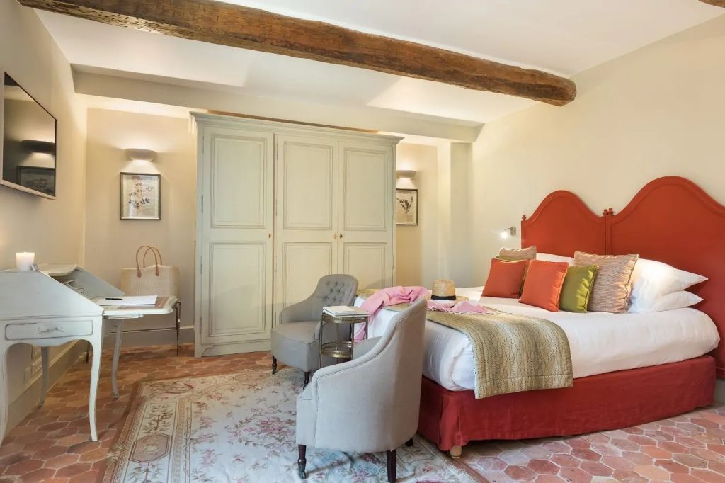 Charmantes Schlafzimmer mit Holzbalken und gemütlicher Sitzecke