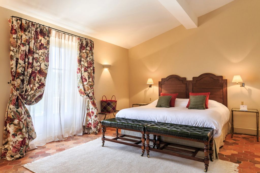Geräumiges Zimmer mit floralen Vorhängen und rustikalem Bodenbelag