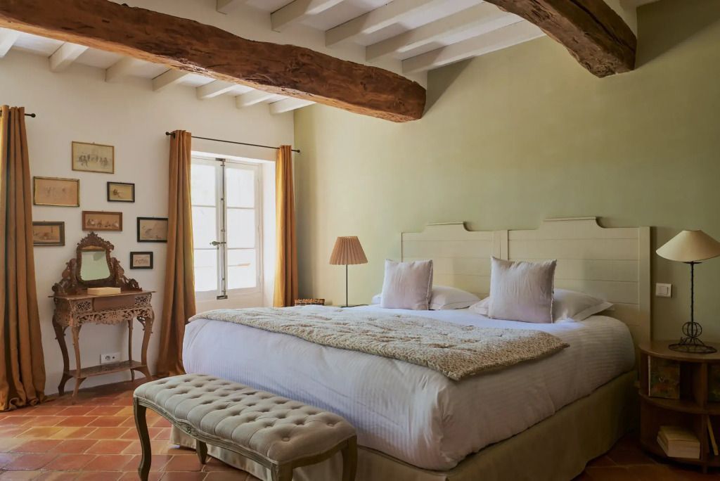 Gemütliches Schlafzimmer mit rustikalen Holzbalken und einem großen Bett.