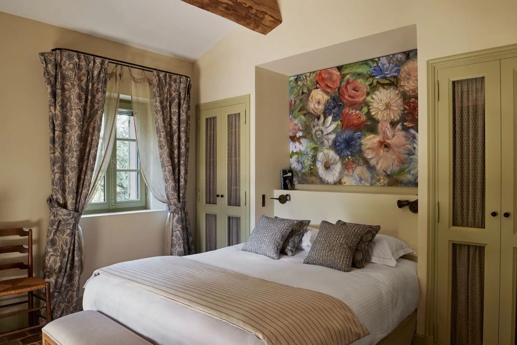 Gemütliches Schlafzimmer mit Blumenbild und rustikalen Akzenten.