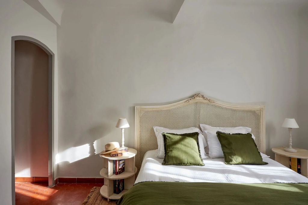 Helles Zimmer mit Doppelbett und grünen Akzenten im klassischen Stil