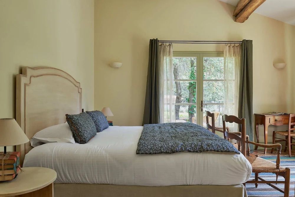 Helles Zimmer mit Doppelbett und Blick auf den Garten im Vanado Villa