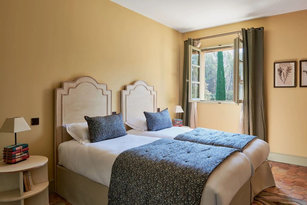 Zweibettzimmer mit offener Fensteransicht auf grüne Landschaft in Vanado Villa