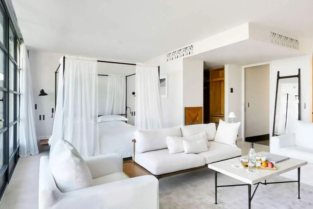 Helle Suite mit Baldachinbett und Sofa in moderner Einrichtung