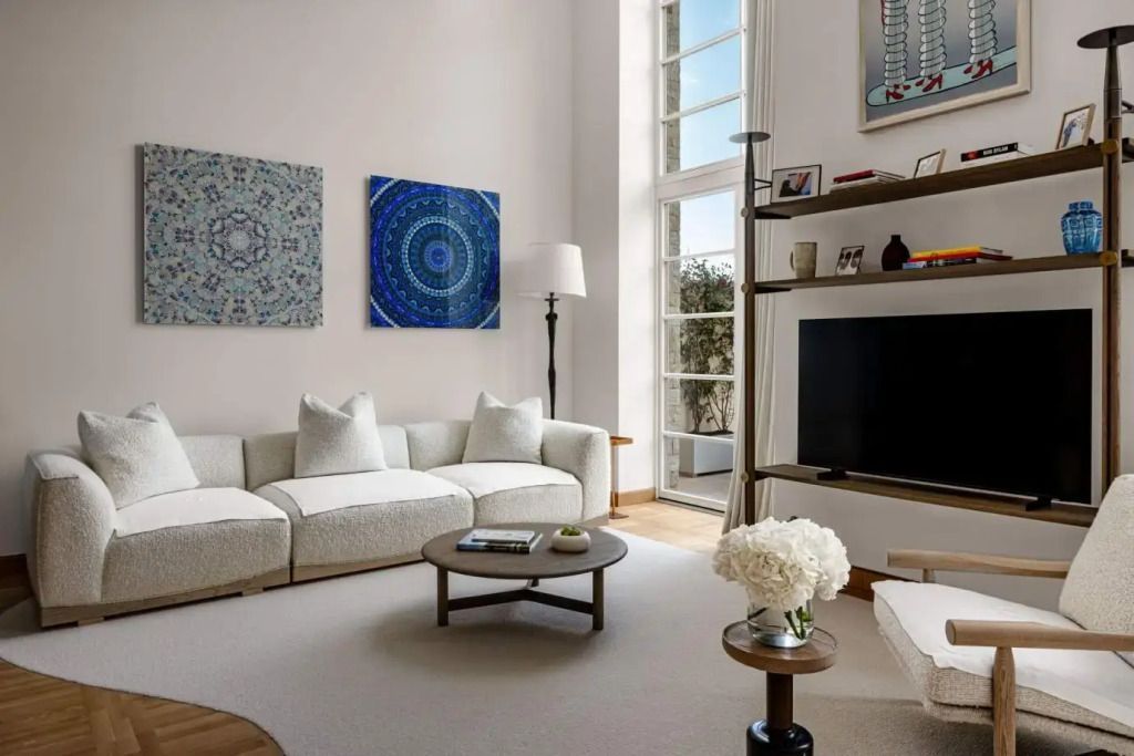 Geräumiges Wohnzimmer mit moderner Kunst und großen Fenstern