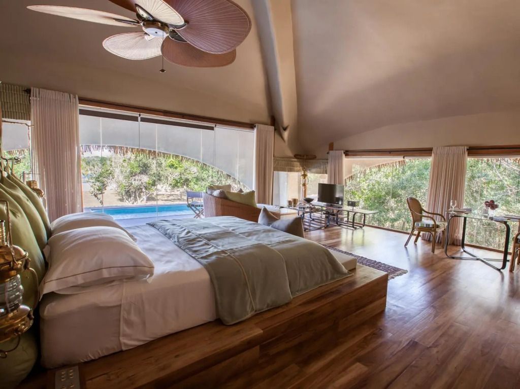 Luxuriöses Doppelzimmer mit Blick auf den Pool und großer Fensterfront