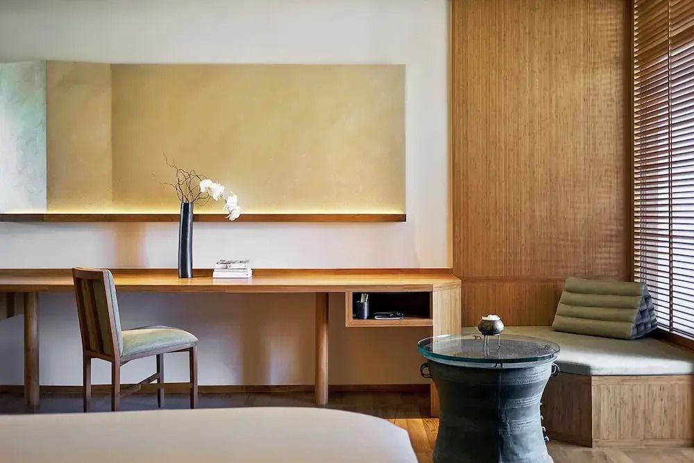 Arbeitsbereich im Deluxe-Zimmer mit Schreibtisch und dekorativen Elementen.