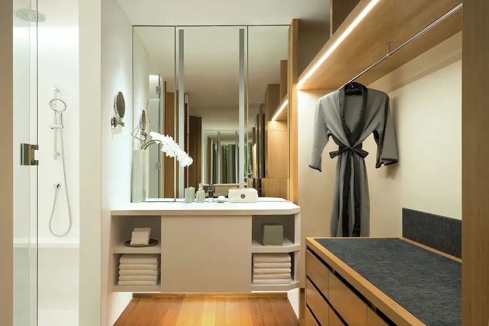 Elegantes Badezimmer mit großer Spiegelwand und luxuriösen Holzakzenten