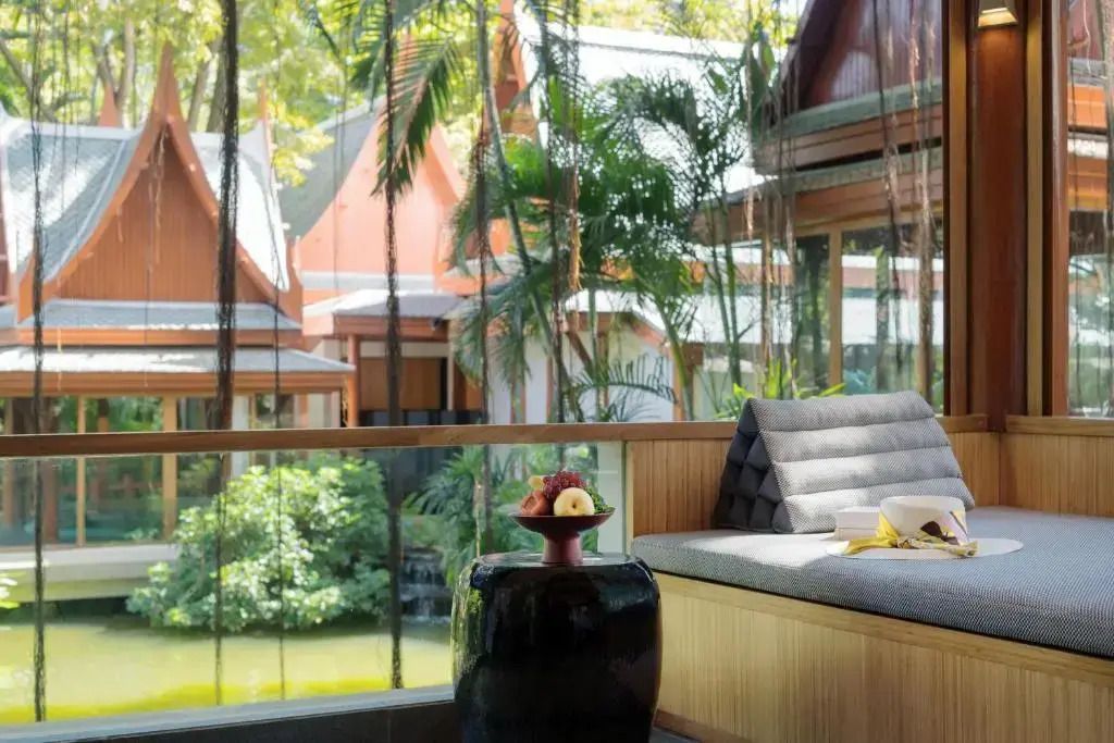 Exotische Gartenansicht von der Zimmerterrasse mit gemütlicher Sitzecke