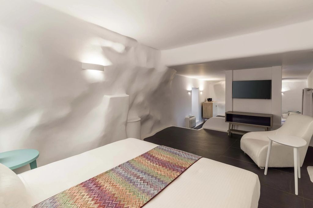 Helles Zimmer mit gewölbten Wänden und gemütlichem Doppelbett in der Suite