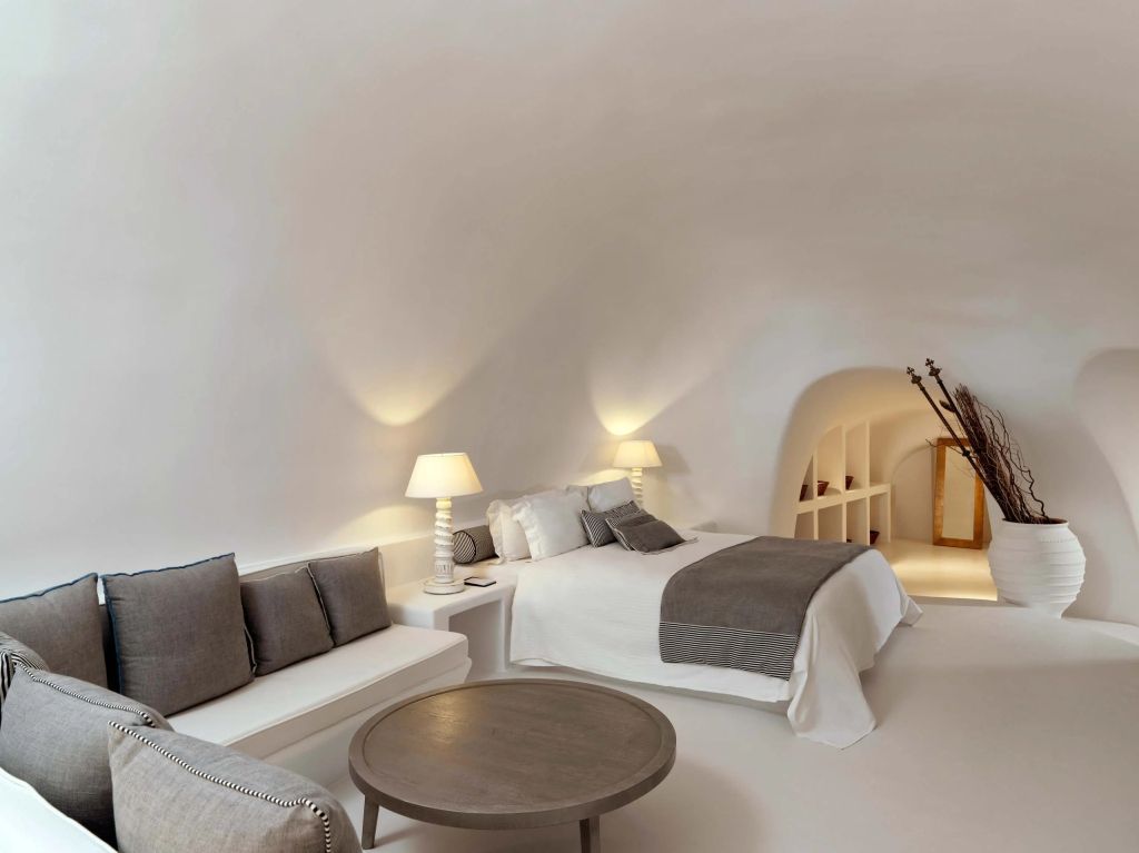 Elegantes Zimmer mit gewölbter Decke, gemütlichem Bett und einladender Sitzecke
