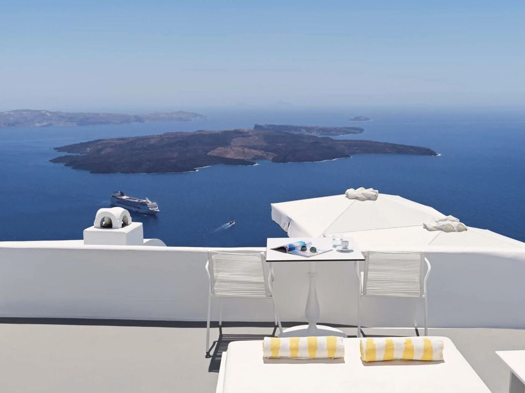 Terrasse mit Blick auf die Ägäis und einem Tisch mit zwei Stühlen.