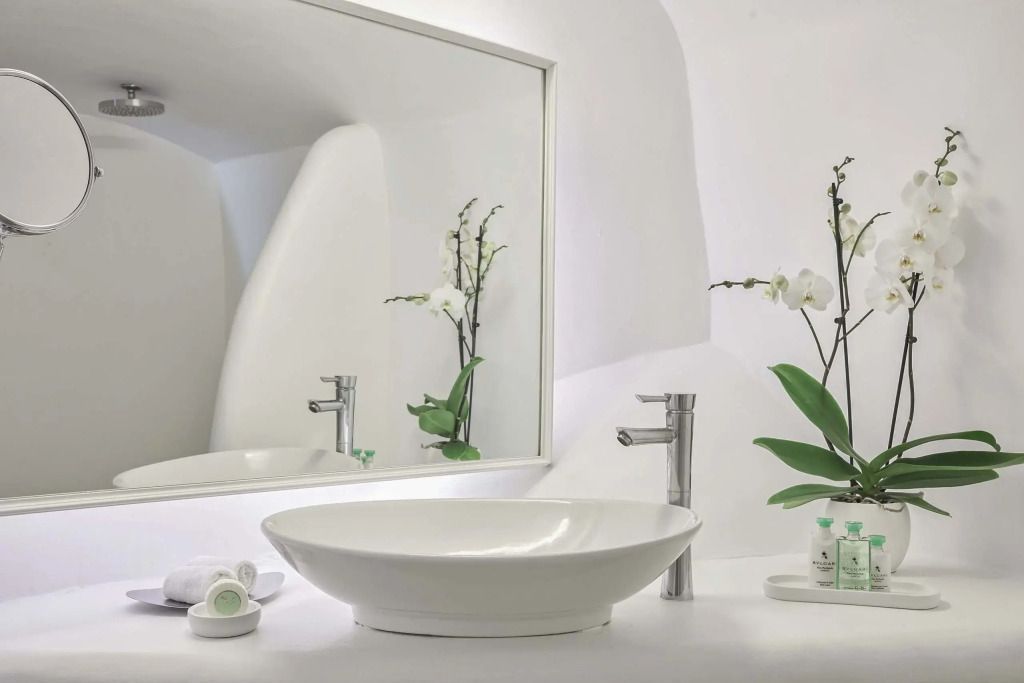 Modernes Badezimmer mit Spiegel und stilvollen Orchideen im Katikies Chromata.