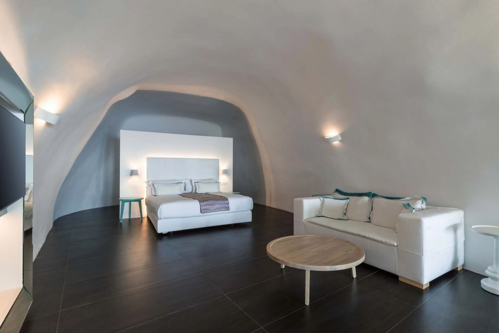 Geräumige Suite mit gewölbter Decke und elegantem Doppelbett in neutralen Tönen