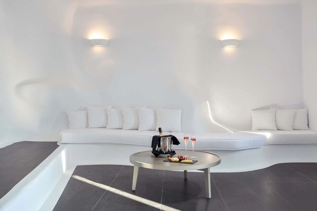 Helles Wohnzimmer mit stilvollem Loungebereich, Champagner und Snacks auf dem Tisch