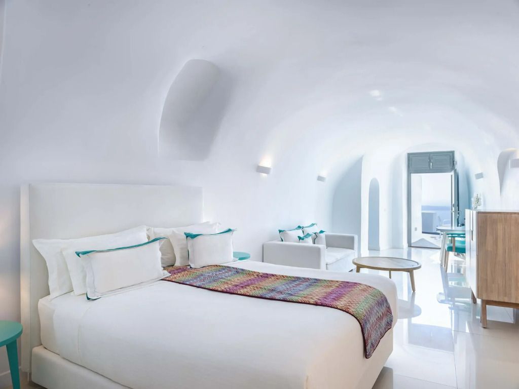 Helles Zimmer mit Doppelbett, moderner Einrichtung und Ausblick auf das Meer