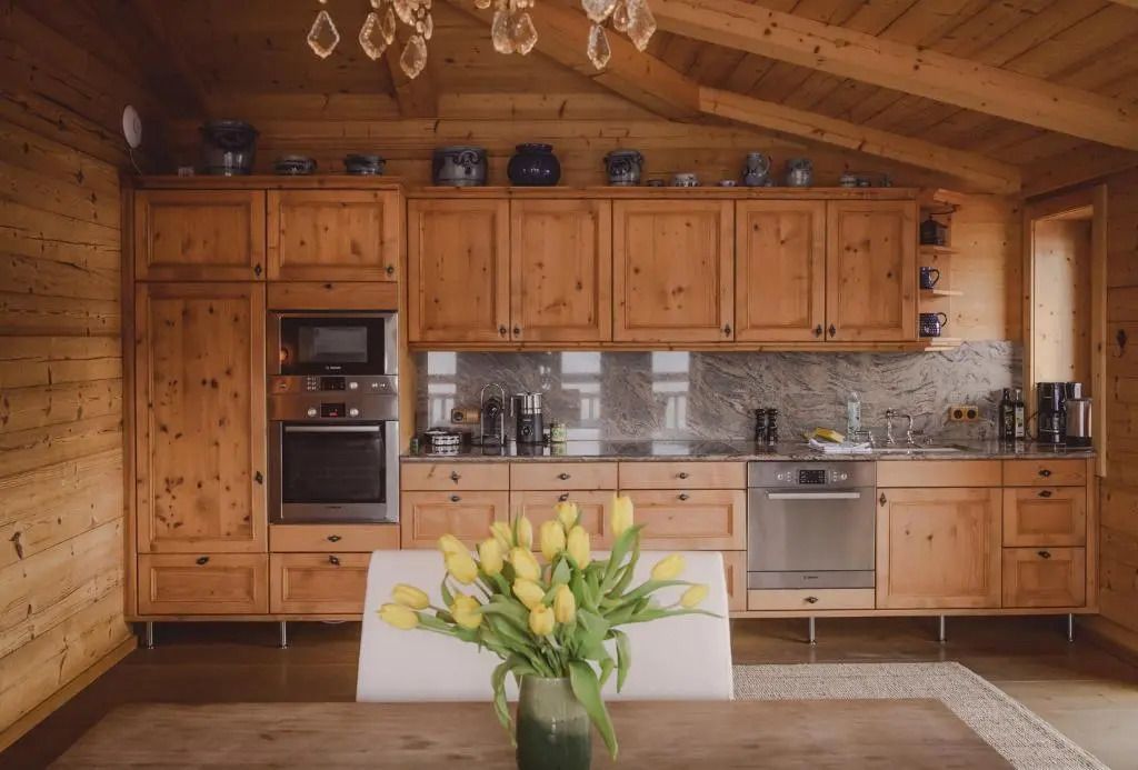 Helles Penthouse mit Holzküche, Esstisch und Blumen