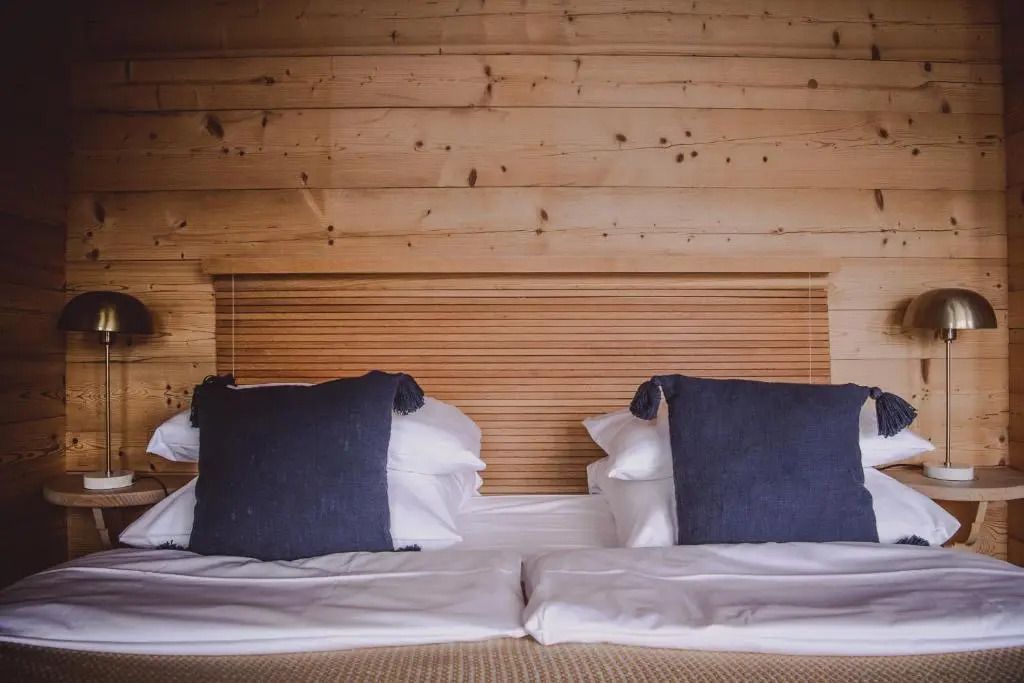 Gemütliches Doppelbett mit Holzvertäfelung und blauen Akzenten