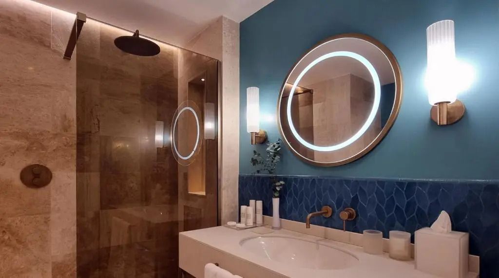 Modernes Badezimmer mit Rundspiegel und eleganten Armaturen