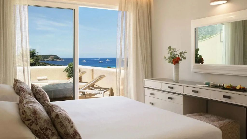 Luxuriöses Schlafzimmer mit Balkonblick auf das Meer im CPH Pevero Hotel