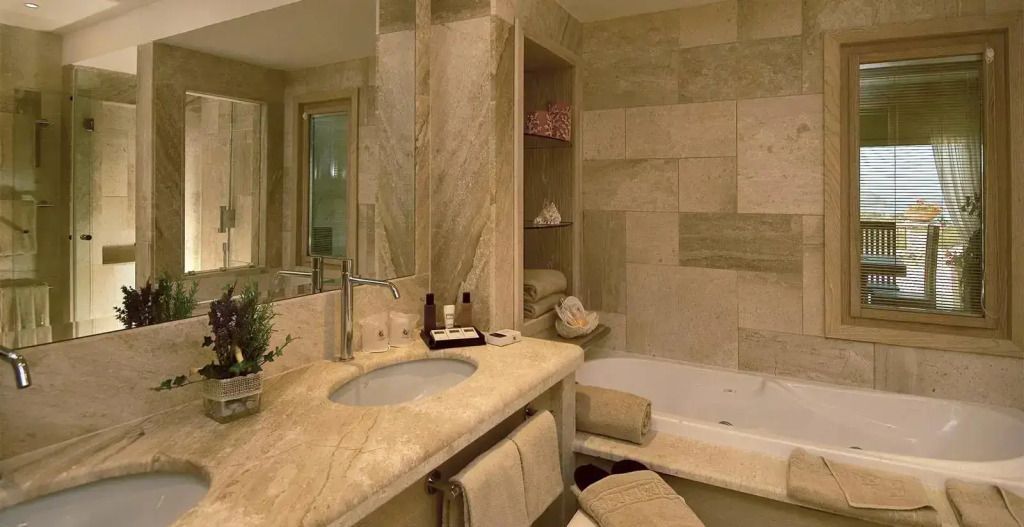 Badezimmer mit edler Marmorverkleidung und integrierter Badewanne