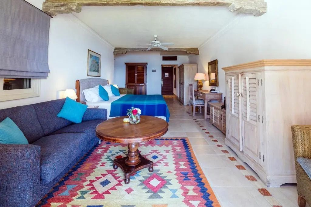 Geräumige Junior-Suite mit Doppelbett, Sofa und farbenfrohem Teppich im Columbia Beach Resort