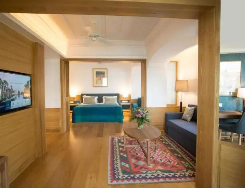Großzügiges Zimmer mit Bett und gemütlicher Sitzecke