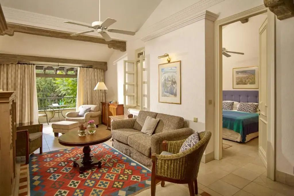 Gemütliches Wohnzimmer mit Sofa und Zugang zu einem Schlafzimmer im Resort.