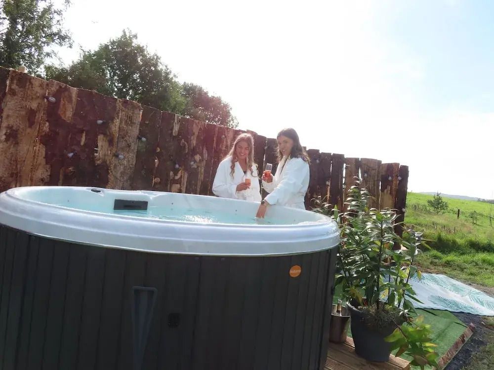 Zwei Personen im Whirlpool im Freien umgeben von Natur