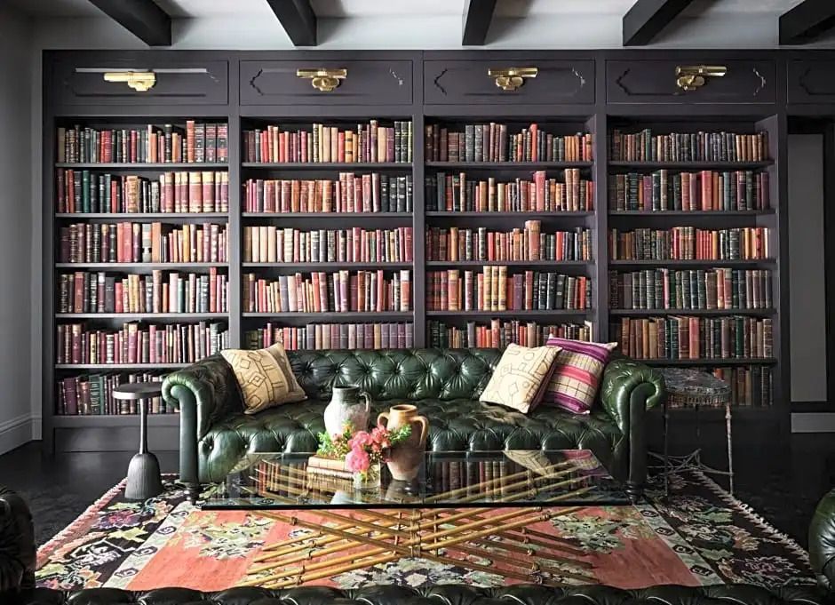 Luxuriöse Bibliothek mit Leder-Sofa und gefüllten Bücherregalen