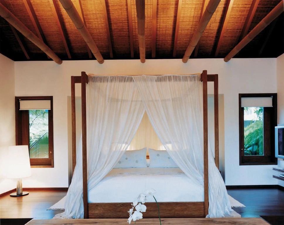 Luxuriöses Schlafzimmer mit Himmelbett und Holzbalkendecke in der Villa
